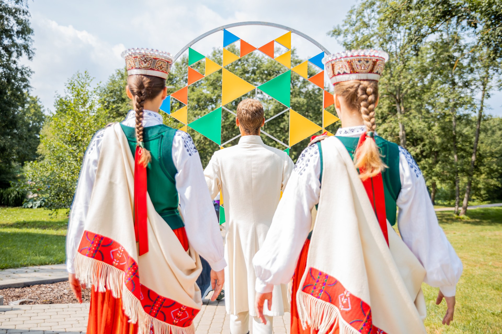 Jóvenes con trajes tradicionales letones en el Festival de la Canción y la Danza de Letonia